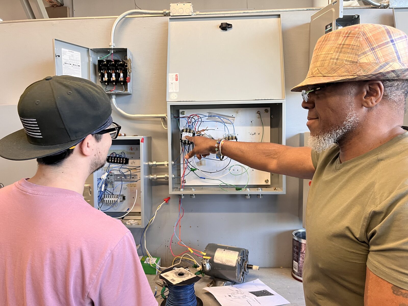 253 HVACR Techs instructor walking a student through a control panel wiring diagnosis